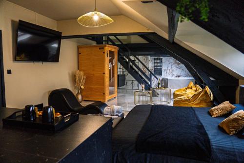 a bedroom with a bed and a tv in a room at La Marble Room - Suite balnéo & sauna in Angers