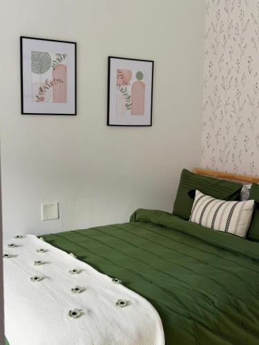 a bedroom with a green bed and two pictures on the wall at Chic Living on Newbury Street in Boston