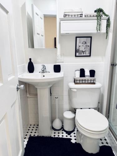a white bathroom with a toilet and a sink at Chic Living on Newbury Street in Boston