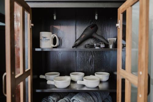 a cabinet with bowls and cups on a shelf at Sr Pilot Earhart Hangar Suite, 2 br K &Q, 1 Ba in Atchison