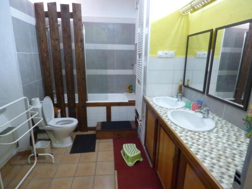 une salle de bain avec deux lavabos et un WC et un miroir dans l'établissement Lincou Beach, à Réquista