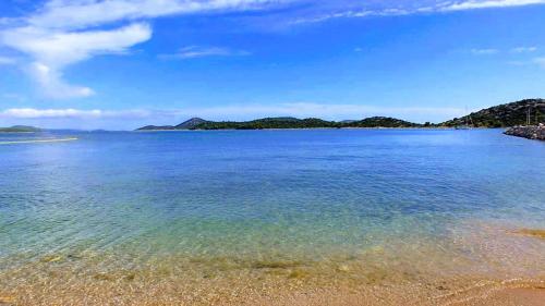 a large body of water with a sandy beach at Apartman Logorun stone house 10 m from the sea in Tribunj