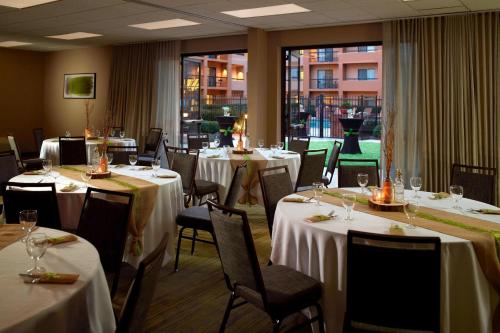a restaurant with tables and chairs with white tablecloths at Courtyard by Marriott Perimeter Center in Atlanta