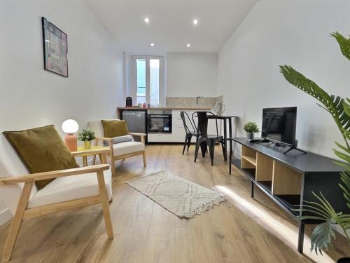 Il comprend un salon doté d'un canapé et d'une table avec une télévision. dans l'établissement Cornas - Centre Historique Calme, à Tournon-sur-Rhône