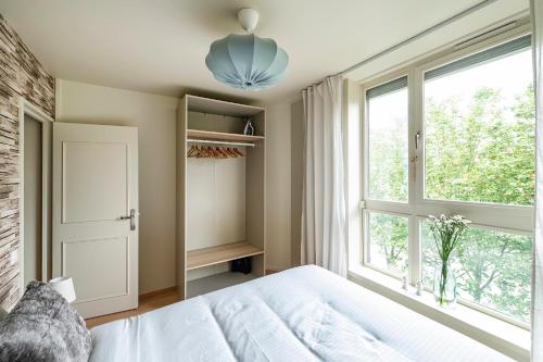 a bedroom with a white bed and a window at Appartements Lake 3 - Duke Housing in Créteil
