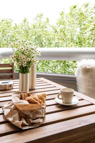 a table with a basket of bread and a cup of coffee at Appartements Lake 3 - Duke Housing in Créteil