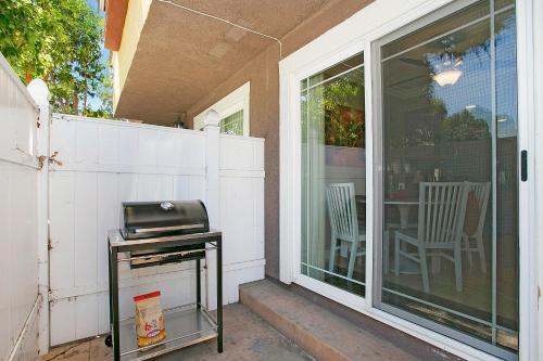 a screened in porch with a grill and chairs at Multi-Level 2BR-Fast WiFI-Free Parking -CM-1 in Costa Mesa
