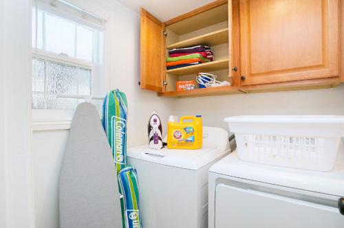 a laundry room with a washer and dryer and a snowboard on top at Multi-Level 2BR-Fast WiFI-Free Parking -CM-1 in Costa Mesa