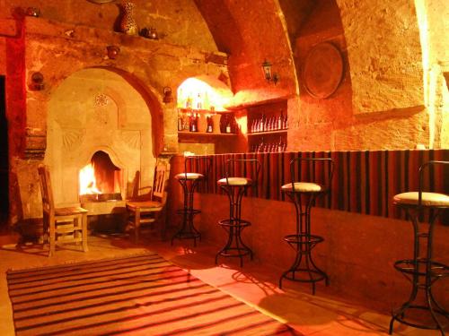 a bar with stools in a room with a fireplace at Karamanli Konagi in Guzelyurt