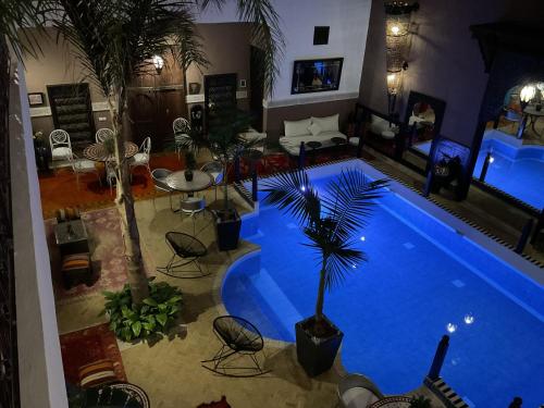an overhead view of a large swimming pool with chairs and a table at Riad Syba in Marrakech