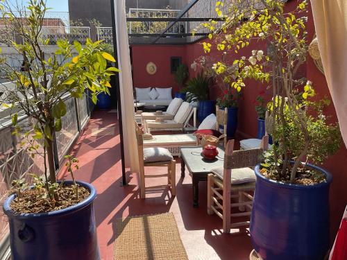 a balcony with potted plants and tables and chairs at Riad Syba in Marrakech