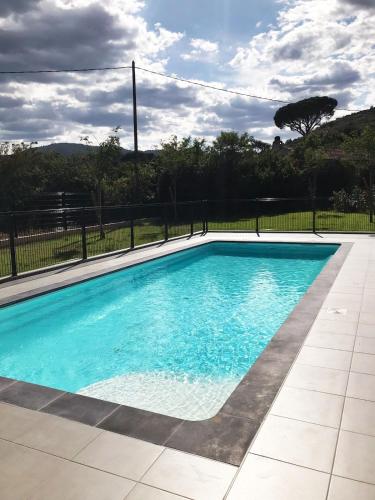 une piscine avec de l'eau bleue dans une cour dans l'établissement Maison Jasmin, Modern, air-conditioned 2-bed with lovely terrace & communal pool, au Plan-de-la-Tour