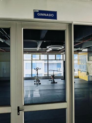 a gym with a glass door in a building at Apto completo Pto Azul Club House Ven a Descansar in Ricaurte
