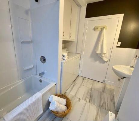 ベー・サン・ポールにあるEspace cozy au coeur de Baie-St-Paulの白い浴槽と洗面台のあるバスルーム