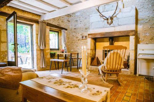 un salon avec une table et une cheminée dans l'établissement Gite romantique avec Sauna, Spa, Home cinéma -La Closerie du Biard-, à Beaumont-du-Périgord