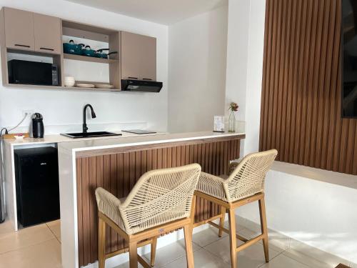 a kitchen with two chairs and a counter with a sink at Villa Condesa Del Mar in Contadora