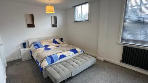 a bedroom with a bed and two windows at Spacious 4 Bedroom House in Leamington Spa