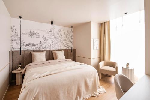 une chambre avec un grand lit et une chaise dans l'établissement The Olympia Suite - Duke Housing, à Paris