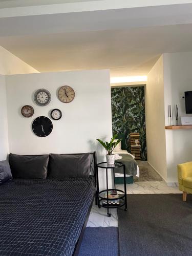 a living room with a couch and clocks on the wall at ΑΘΗΝΑ HOME in Ioannina