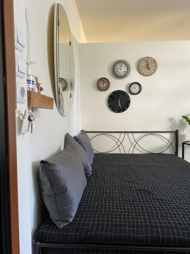 a bedroom with a bed with clocks on the wall at ΑΘΗΝΑ HOME in Ioannina