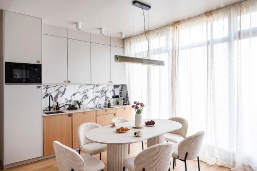 une salle à manger avec une table et des chaises blanches dans l'établissement The Olympia Suite - Duke Housing, à Paris