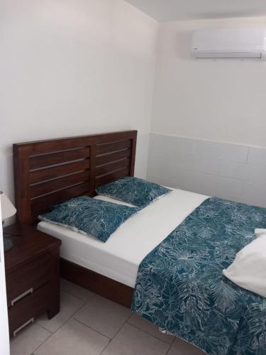 a bedroom with two twin beds and a night stand at La source bis, Mer et source d'eau chaude in Bouillante