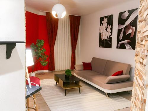 un salon avec un canapé et une table dans l'établissement L'Écarlate - Centre Ville - NyuLocation, à Épinal