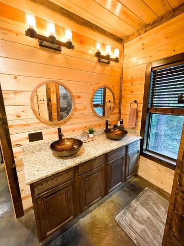 a bathroom with two sinks in a log cabin at The Cozy Endless Sunset Cabin! in Broken Bow
