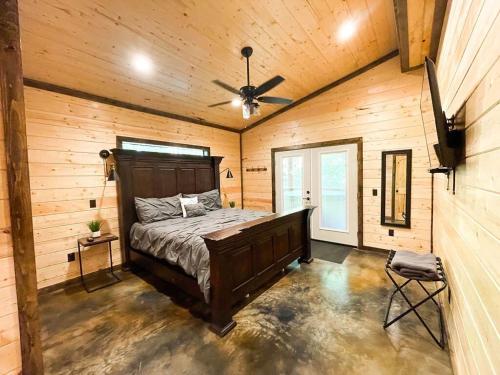 Un dormitorio con una cama y un ventilador de techo. en The Cozy Endless Sunset Cabin!, en Broken Bow