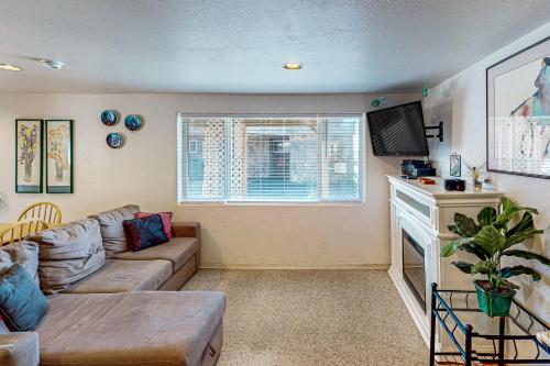 a living room with a couch and a fireplace at Flounder's Crib Condo in Lincoln City