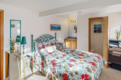 a bedroom with a bed with a floral bedspread at Flounder's Crib Condo in Lincoln City