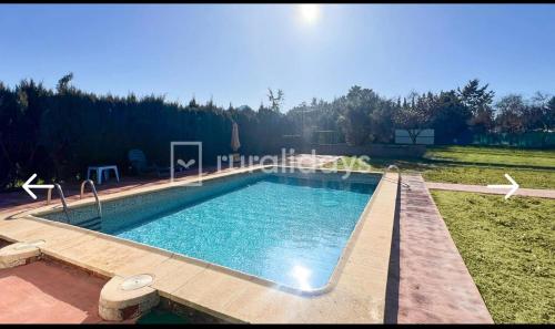 a large swimming pool in a grassy yard at Villa Antaquira in Antequera