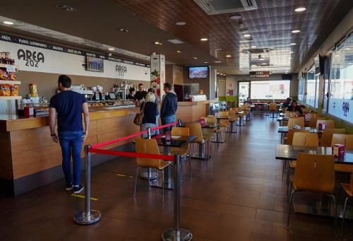 a group of people standing at the counter of a restaurant at Área 202 in Ferreruela de Huerva