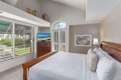 a bedroom with a large white bed and a window at The Palms at Wailea 702 in Wailea