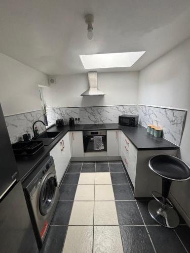 a kitchen with a sink and a washing machine at Cosy Charming room in big house in Little Hulton