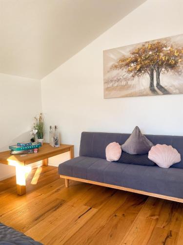 a living room with a blue couch and a table at Apartment Auszeit in Reith bei Seefeld