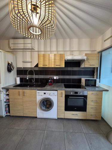 une cuisine avec un évier et une machine à laver dans l'établissement A deux pas des thermes et de l'étang de Thau, à Balaruc-les-Bains