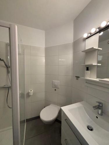 une salle de bain blanche avec des toilettes et un lavabo dans l'établissement A deux pas des thermes et de l'étang de Thau, à Balaruc-les-Bains