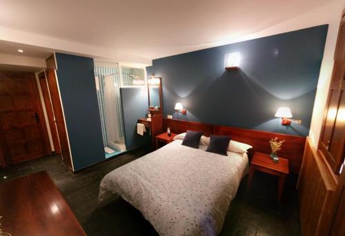 a bedroom with a bed with a blue wall at Hoyo de Los Lobos in Hoyocasero