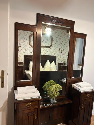 a mirror on a wooden dresser with a vase of plants at CHATA PODLESOK in Hrabušice
