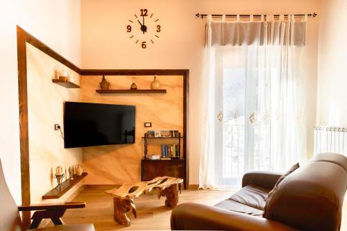 a living room with a couch and a clock on the wall at appartamento NONNA ROSA in Morano Calabro