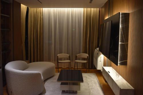 a living room with two chairs and a tv at Stayinn Emerald Shkoder in Shkodër