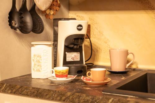 a counter with two cups and a coffee maker at appartamento NONNA ROSA in Morano Calabro