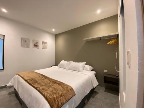 a bedroom with a large white bed in a room at 96K Premium Suite - Habitaciones a minutos del Aeropuerto en Bogotá in Bogotá