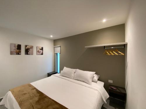 a bedroom with a large white bed in a room at 96K Premium Suite - Habitaciones a minutos del Aeropuerto en Bogotá in Bogotá
