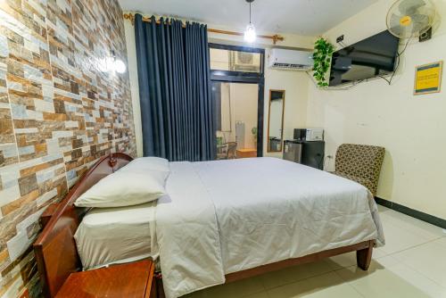 a bedroom with a bed and a brick wall at Hospedaje Gran Imperial in Tumbes