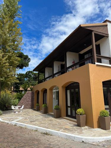 a house with a patio in front of it at Vila Suzana Parque Hotel in Canela