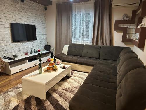 a living room with a couch and a tv at Apartman Centrum in Županja