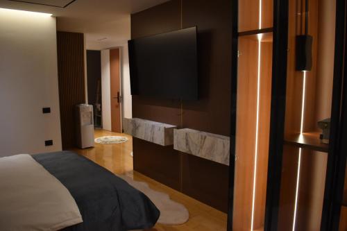 a bedroom with a bed and a flat screen tv at Stayinn Emerald Shkoder in Shkodër