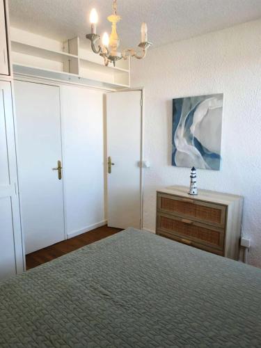 - une chambre avec un lit, une commode et un lustre dans l'établissement Résidence Palmyra - T2 - 4 pers - vue sur l'eau MAE-5491, au Barcarès